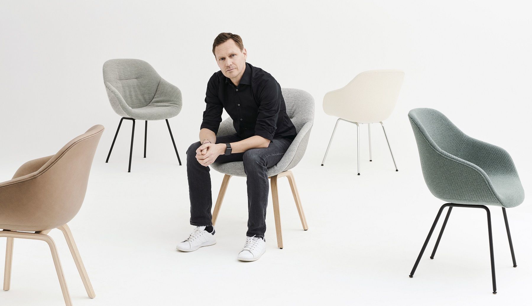Mann sitzt auf einem grauen About a Chair AAC 213 Stuhl von Hay.