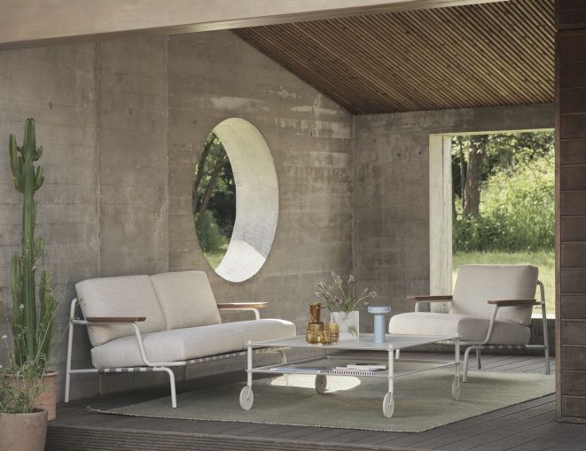 Muuto Settle Lounge Chair Sessel Outdoor mit Sofa und Tisch auf einer Terrasse.