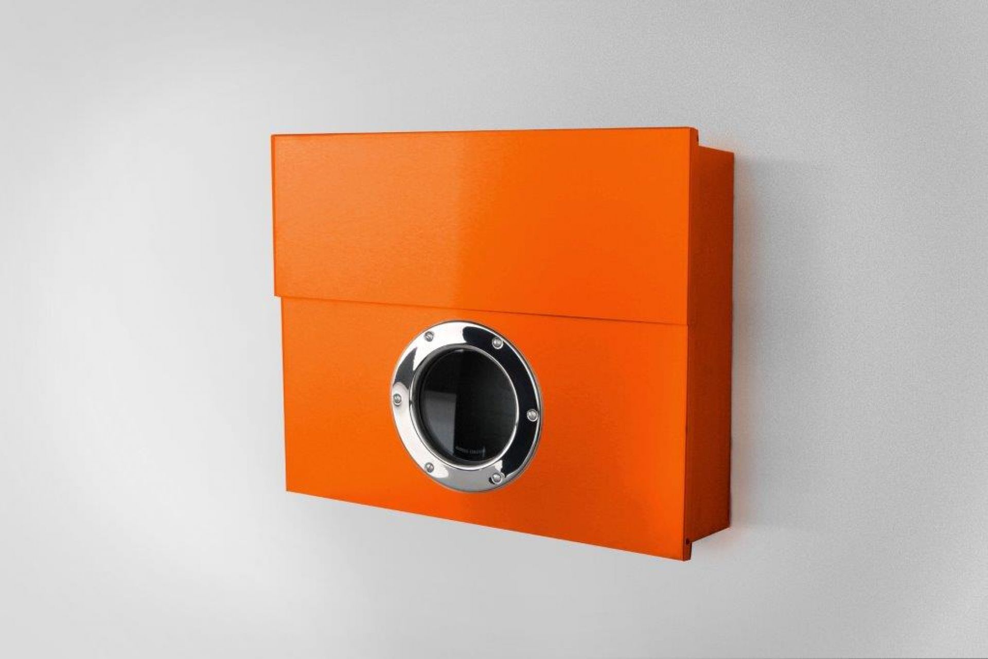 Oranger Letterman Briefkasten mit Sichtfenster an einer weißen Wand. Moderner XXL Briefkasten.