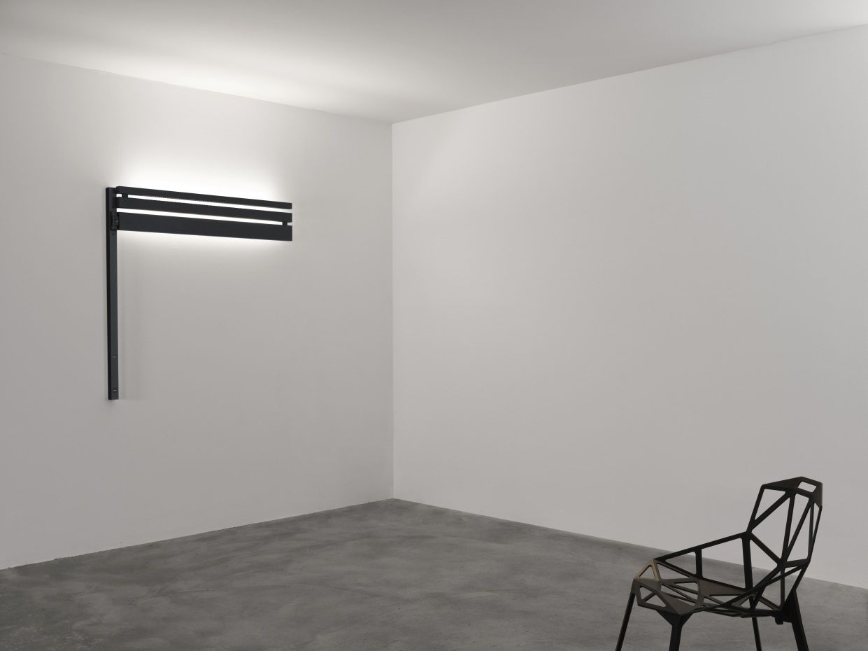 Nahaufnahme der modernen Black Flag Wandleuchte von Flos, minimalistisches Design, indirekte Beleuchtung, schwarze Metallstruktur.
