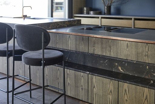 Schwarzer Series 430 Bar Stool Barhocker mit Samtbezug vor einer modernen Kücheninsel mit Marmor.