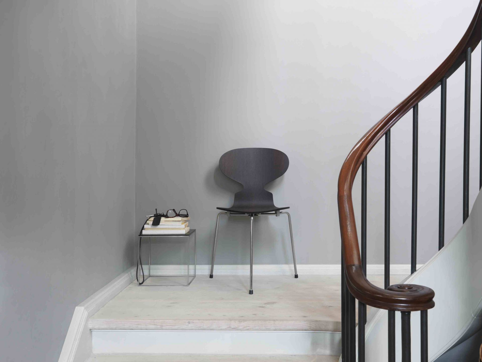 Die Ameise Stuhl von Fritz Hansen mit 3-Bein Gestell in dunklem Holz auf Treppe.