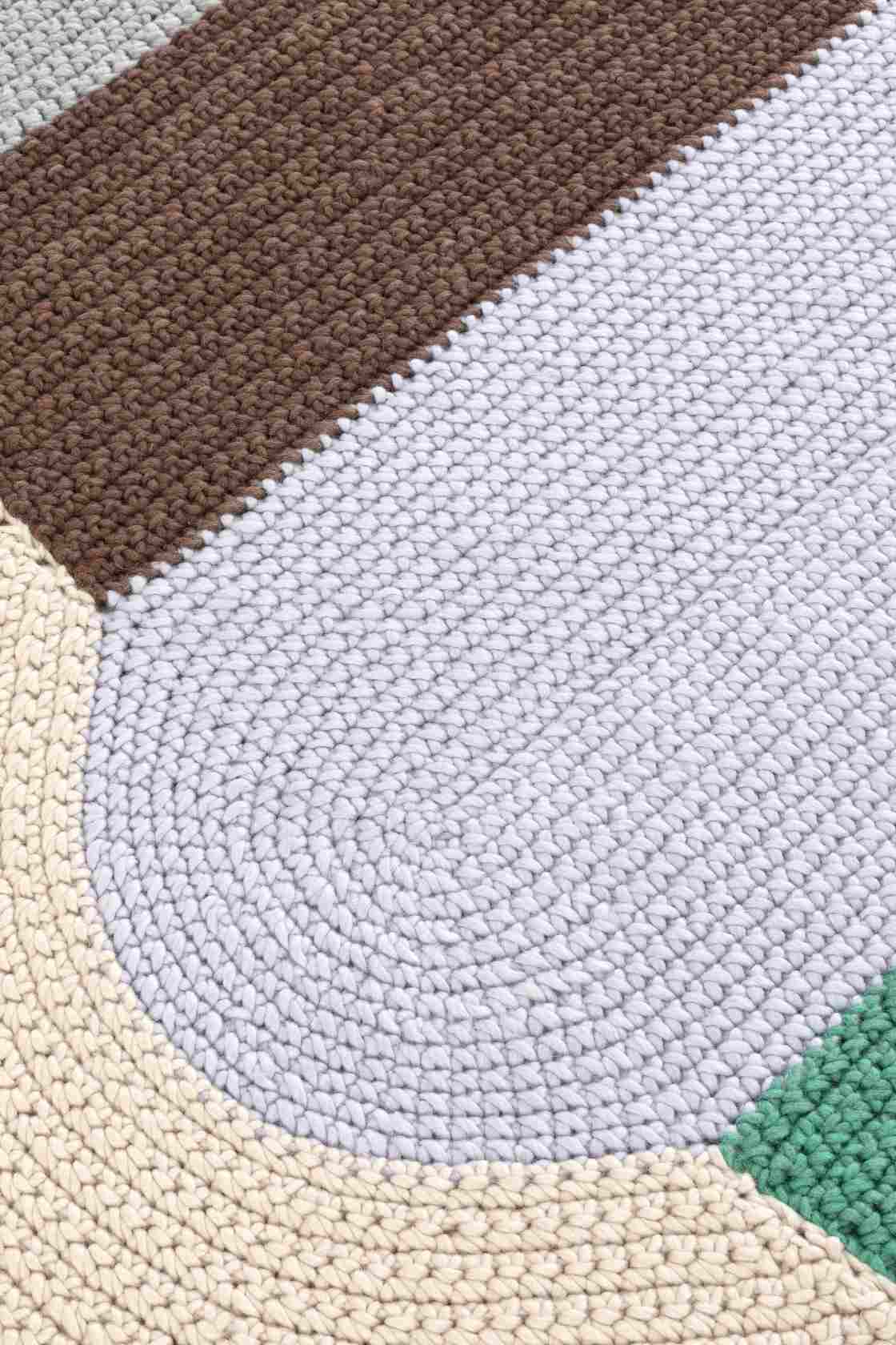 Detailaufnahme des The Crochet Collection Teppichs in Braun, Grau, Beige und Grün, gehäkeltes Muster.