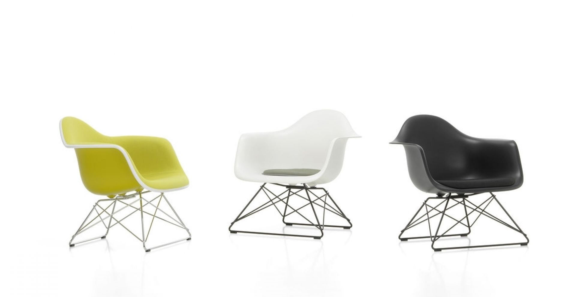 Drei Eames Plastic Arm Chairs LAR von Vitra in Gelb, Weiß und Schwarz auf weißem Hintergrund.