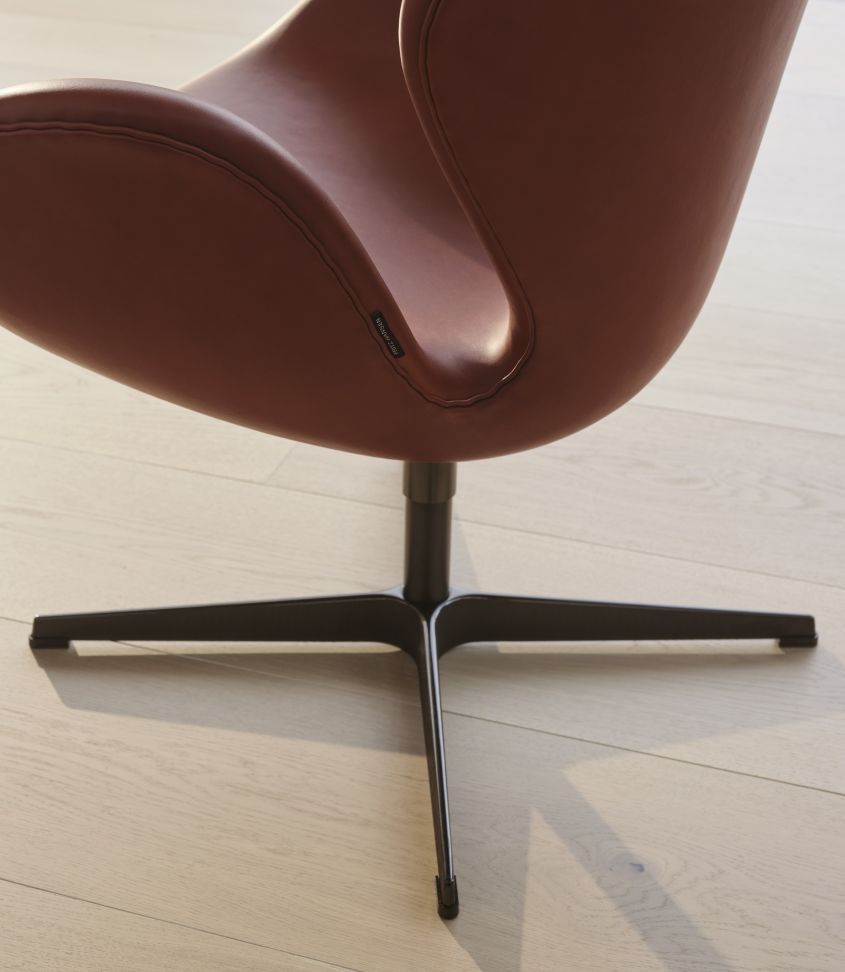 Detailaufnahme: Schwan Sessel von Fritz Hansen, Jubiläumsmodell mit kastanienbraunem Grace Leder.