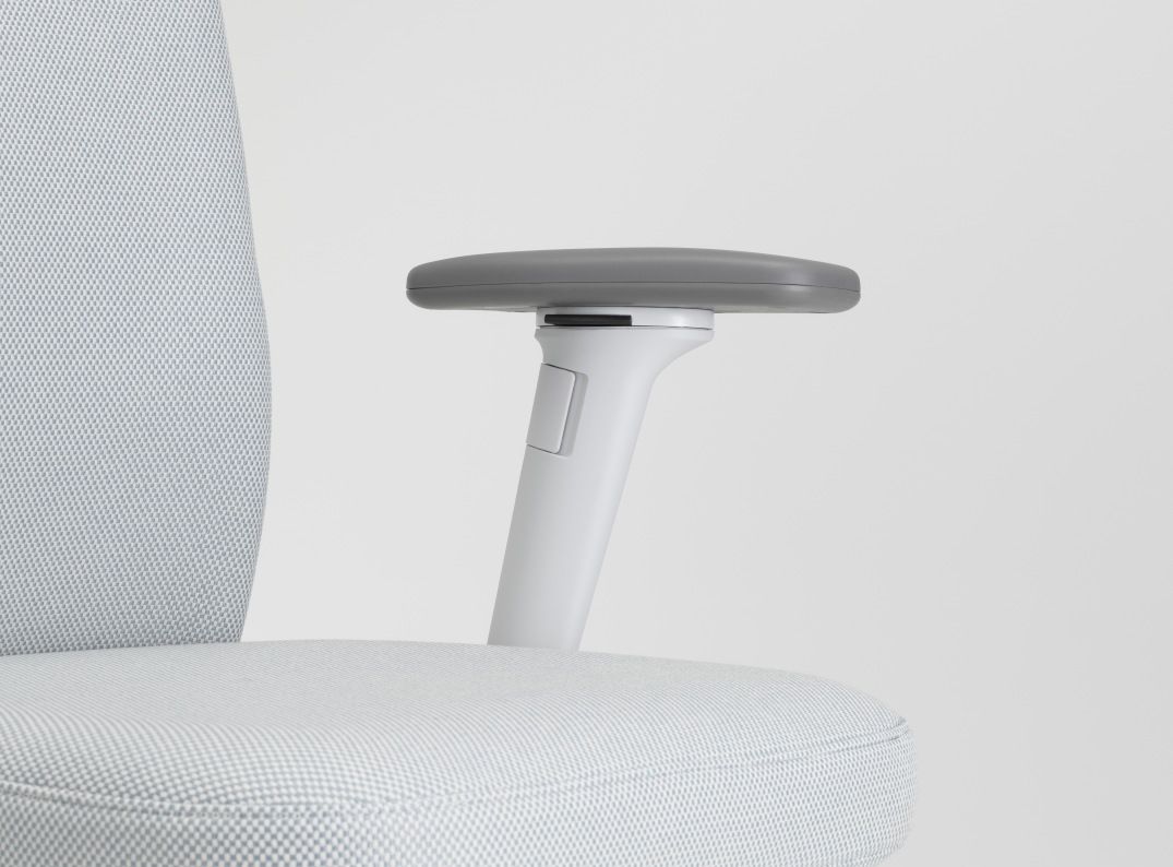 Detailaufnahme des Vitra ID Chair Soft Bürodrehstuhls mit grauen Armlehnen und hellgrauem Stoffbezug.