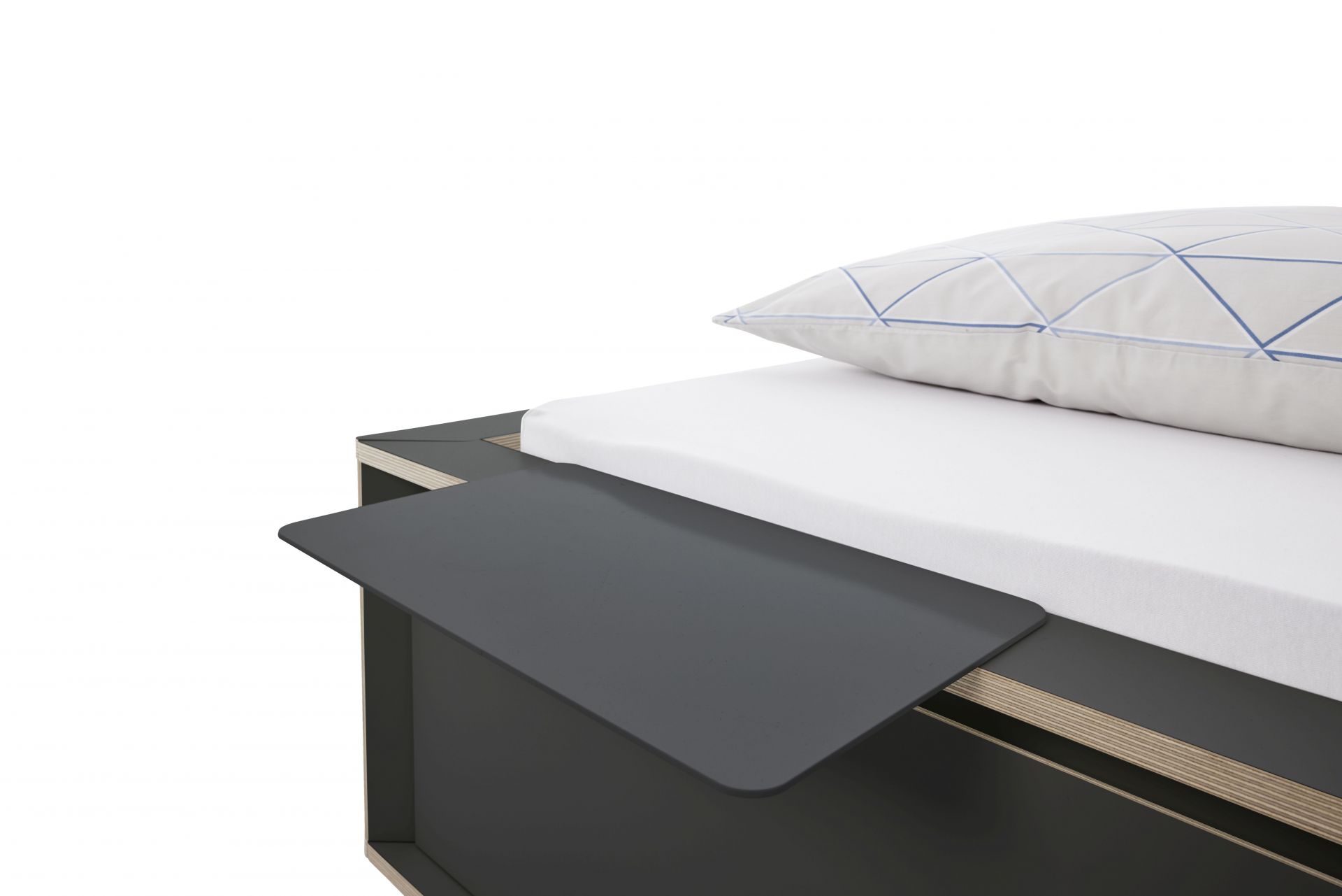 Spaze Bett von Müller Möbelwerkstätten mit grauem Nachttisch und weißem Kissen mit blauem Muster.