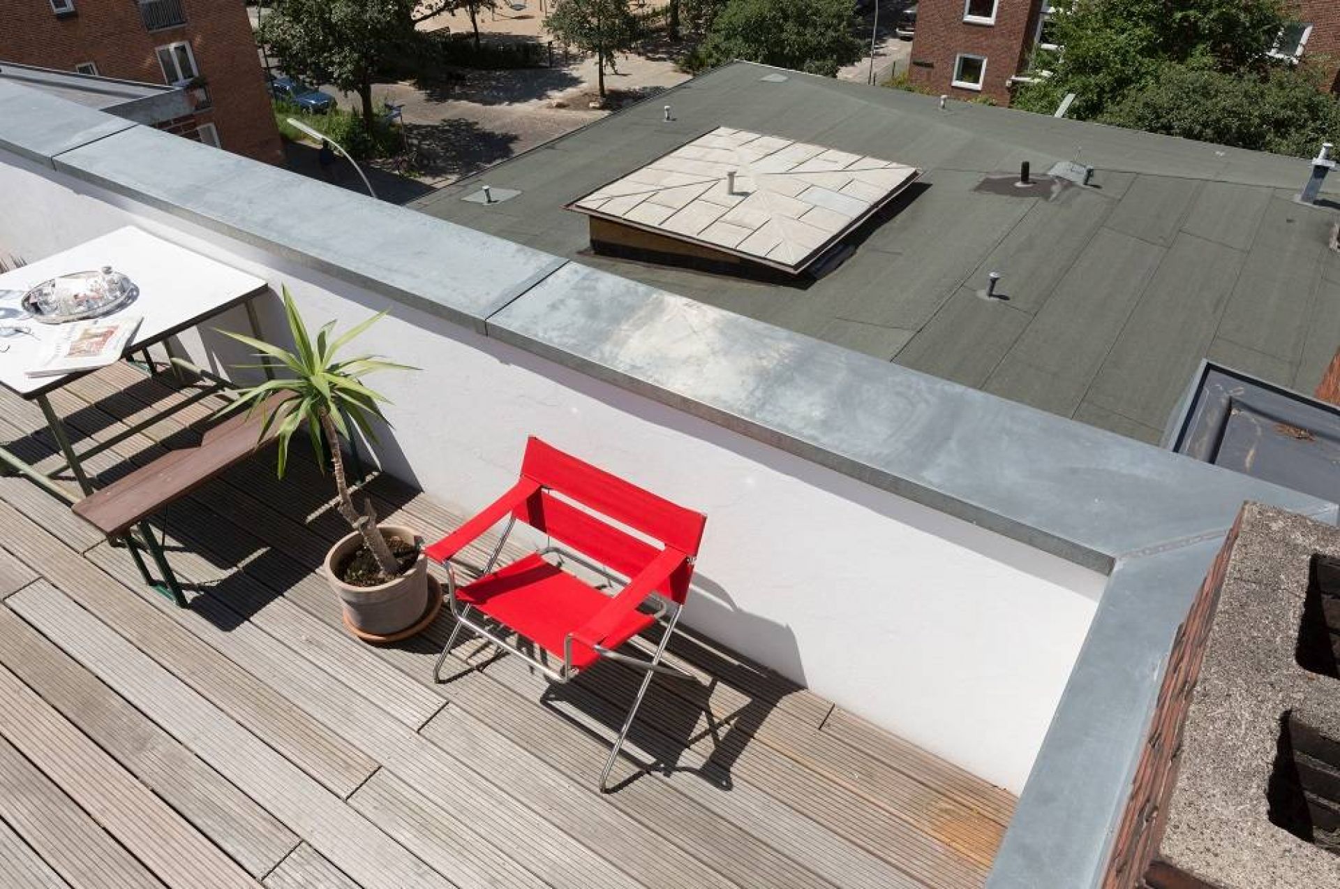Roter Bauhaus Faltsessel von Tecta (D4) auf einer Dachterrasse, modernes Design.