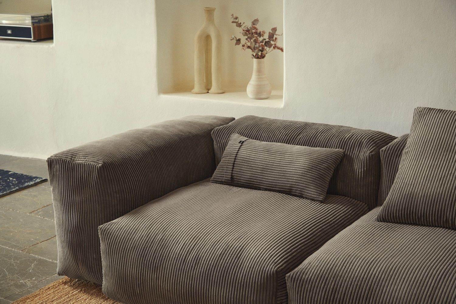 Nahaufnahme des vetsak Pillow Set, ein Kissen-2er Set aus Cordstoff in Grau auf einem Sofa.