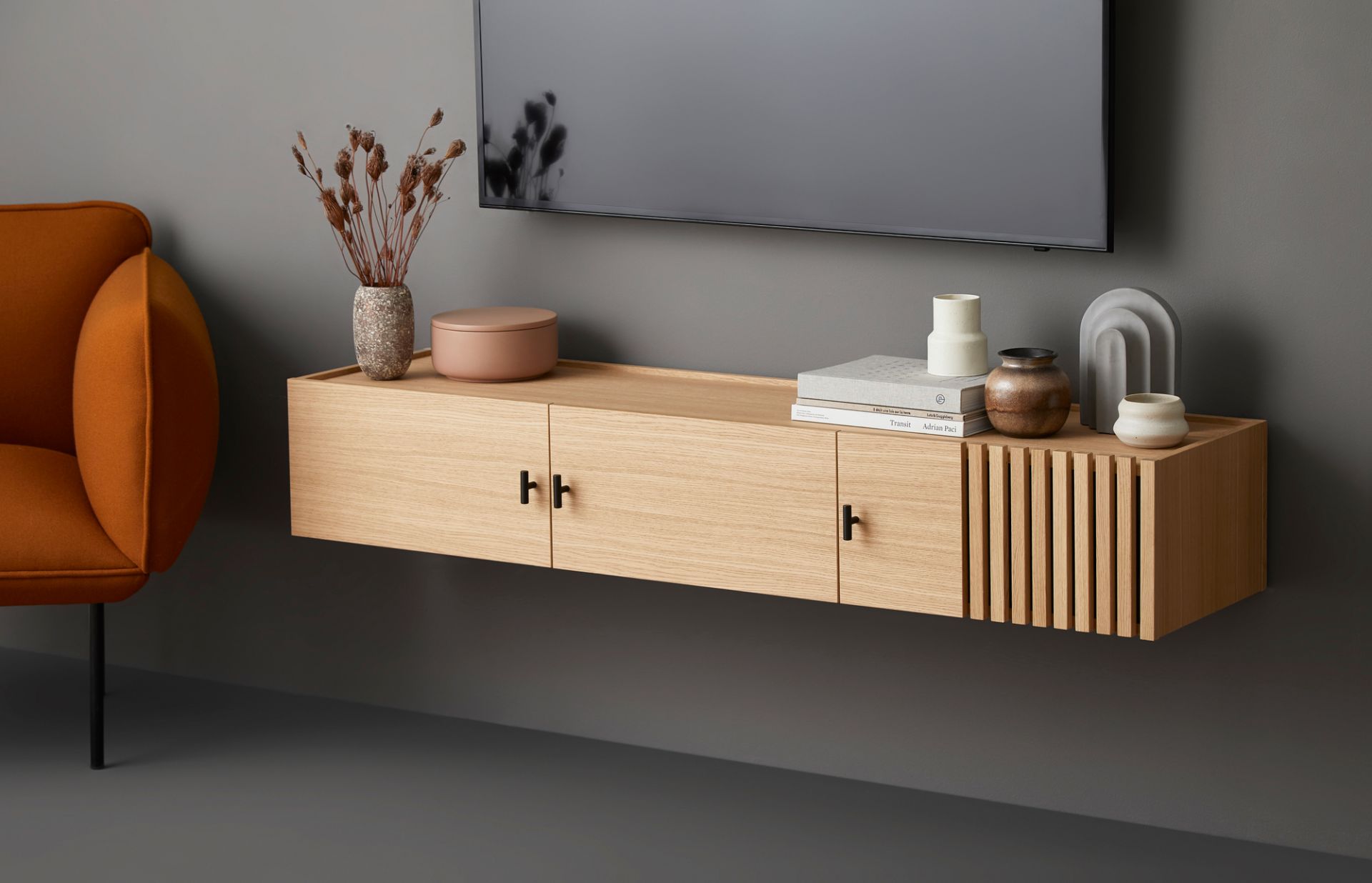 Woud Array Sideboard: Wandmontiertes Lowboard aus hellem Holz mit Schubladen und Dekoration.