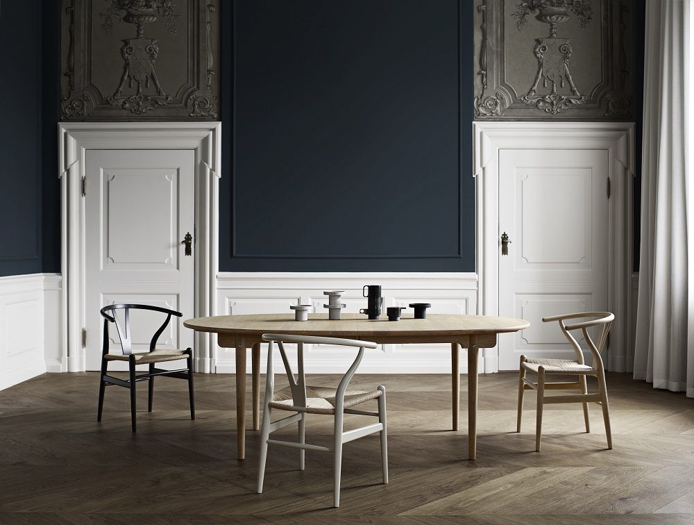 Esszimmer mit ovalem Holztisch und drei CH24 Wishbone Stühlen von Carl Hansen in Soft Farben.