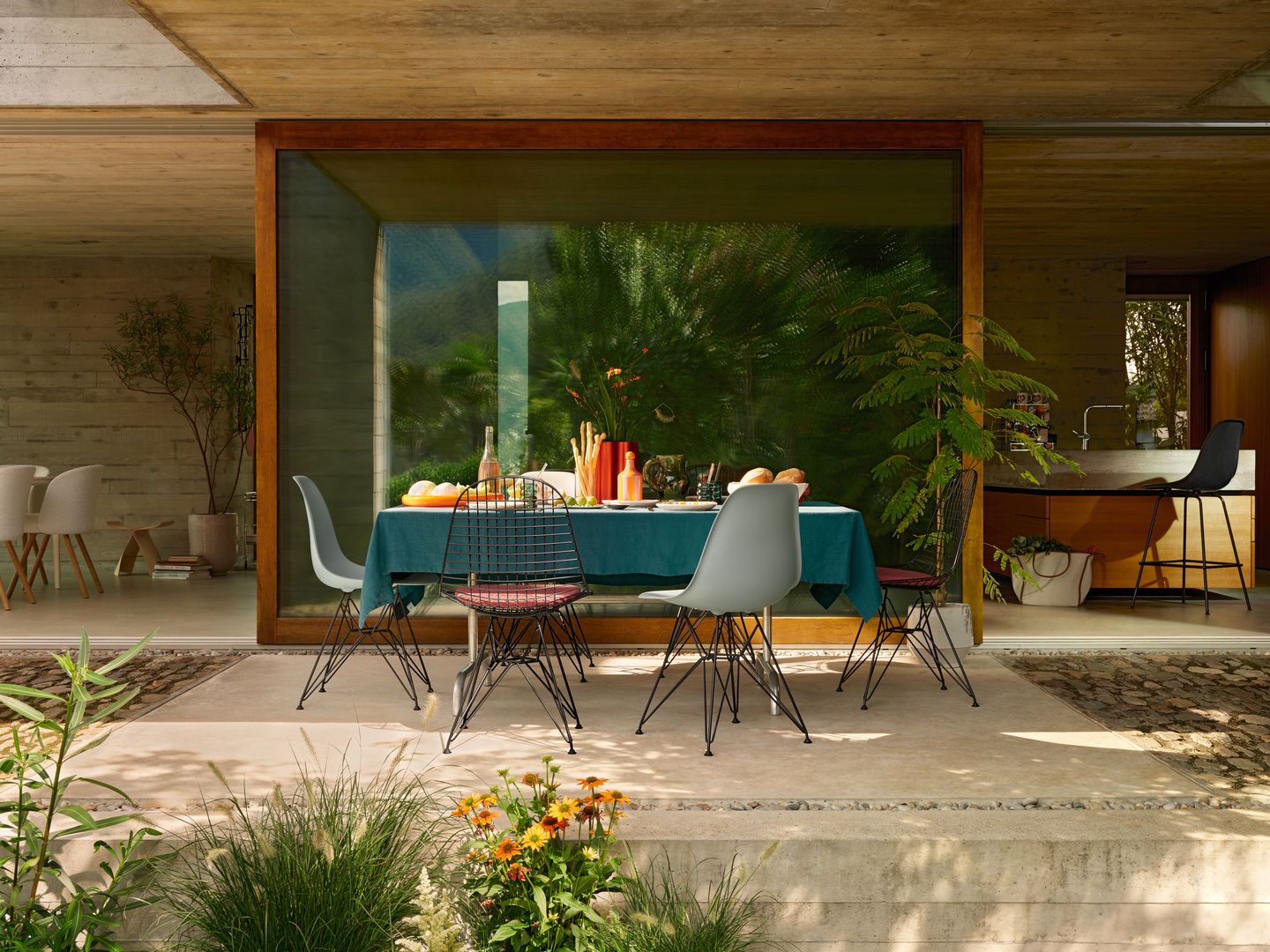 Eames DSR Stühle von Vitra mit Sitzpolster an Esstisch im Freien. Designklassiker.