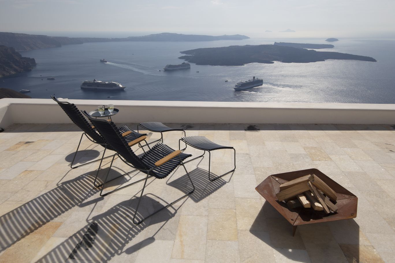 Outdoor-Szene mit Click Fußhocker von Houe, schwarzes Design, Meerblick, Entspannung im Freien.