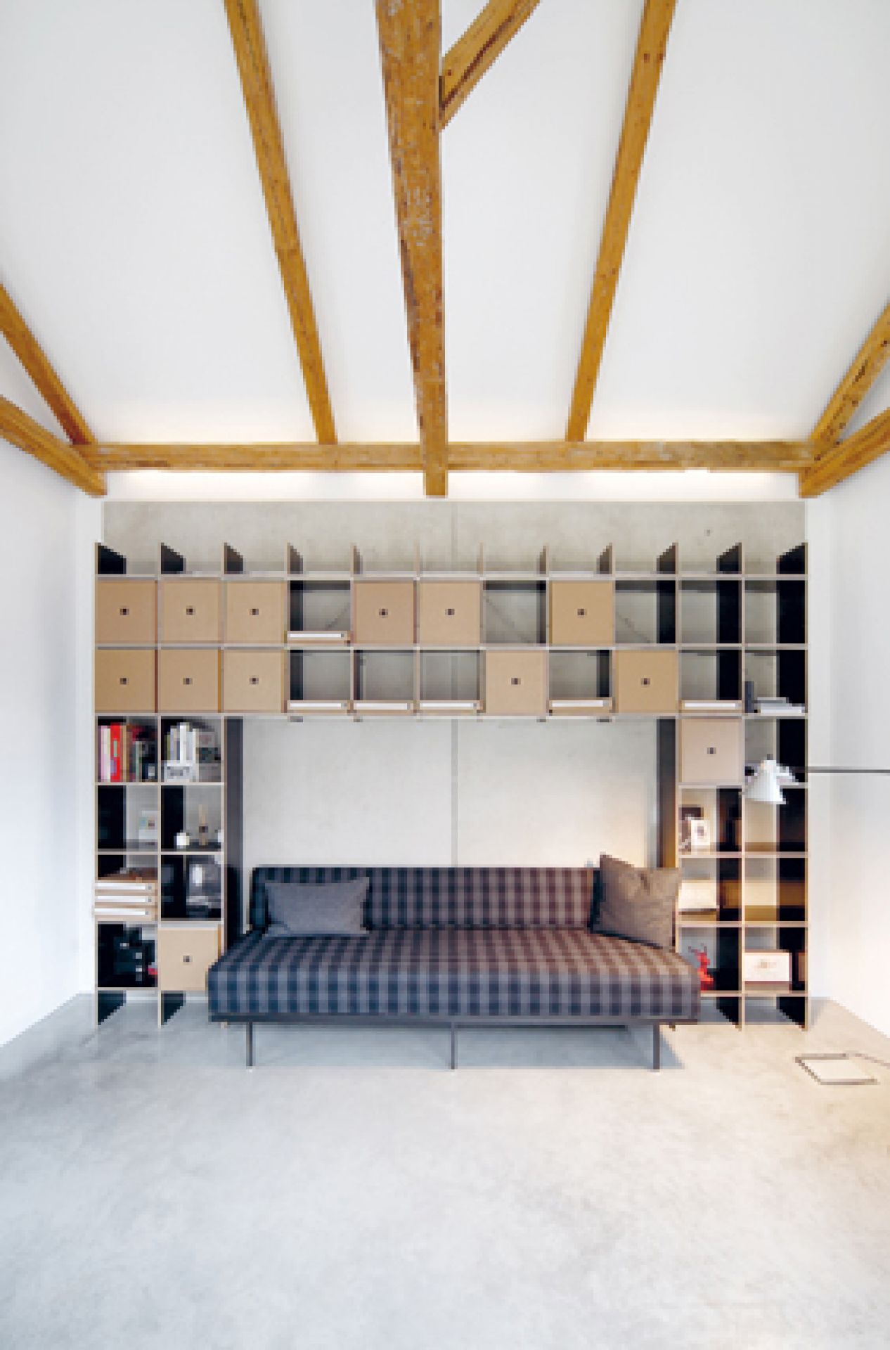 FNP Regal von Nils Holger Moormann in modernem Wohnzimmer mit Sofa und Holzbalken.