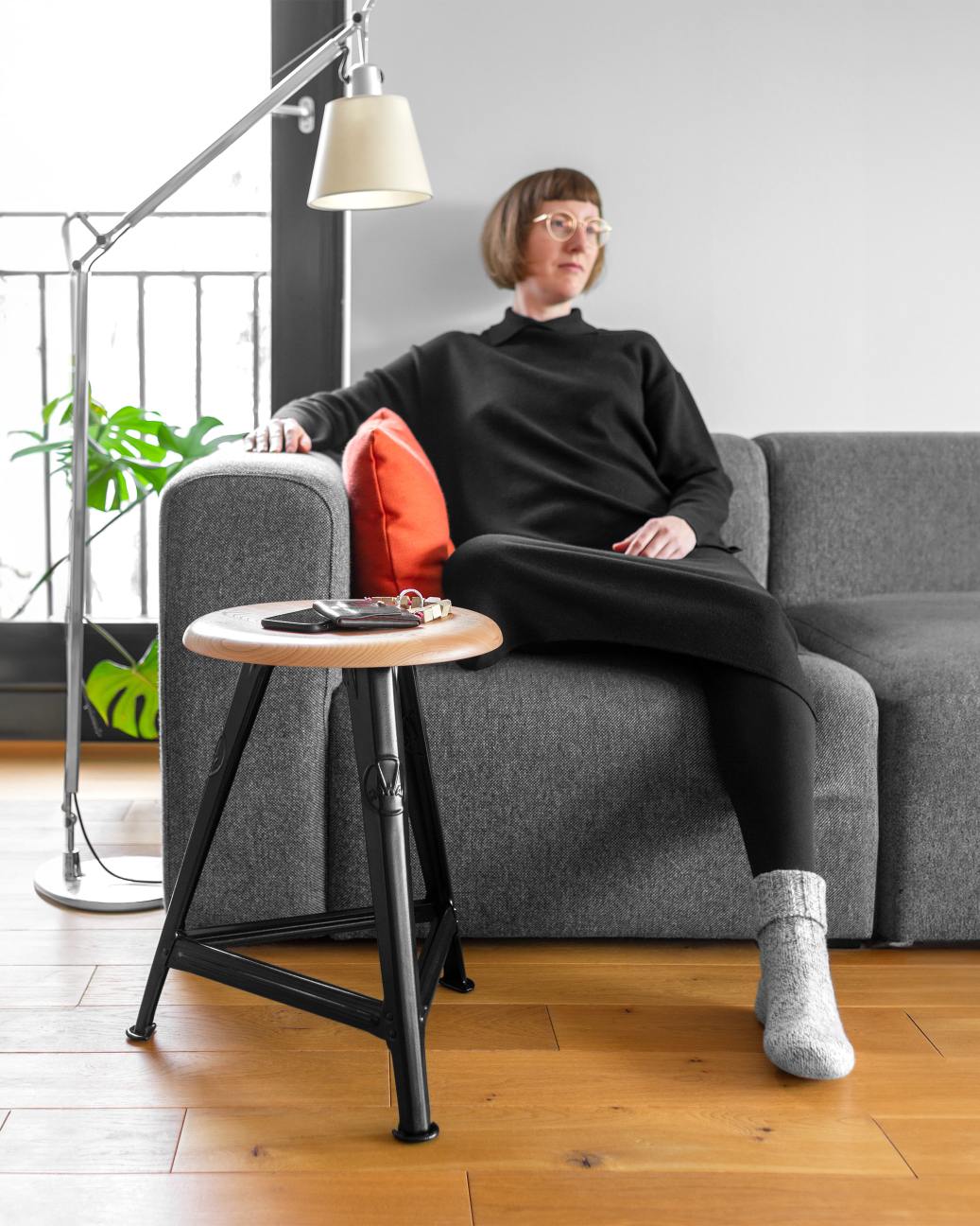 Rowac Schemel Model I 50 cm Hocker aus Holz und Stahl, genutzt als Beistelltisch neben Sofa.
