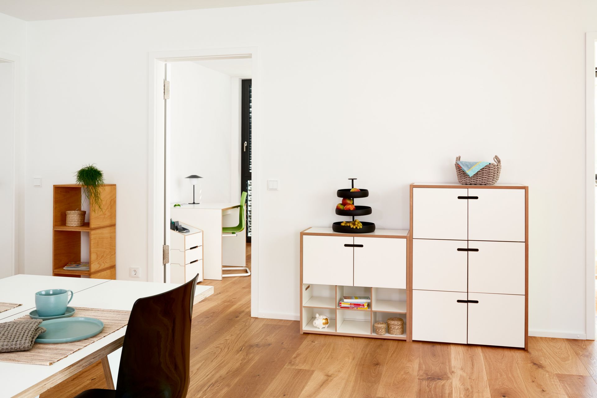 Helles Wohnzimmer mit Tojo Hochstapler Regal Grundmodul mit Türen, flexibel erweiterbar und modern designt.