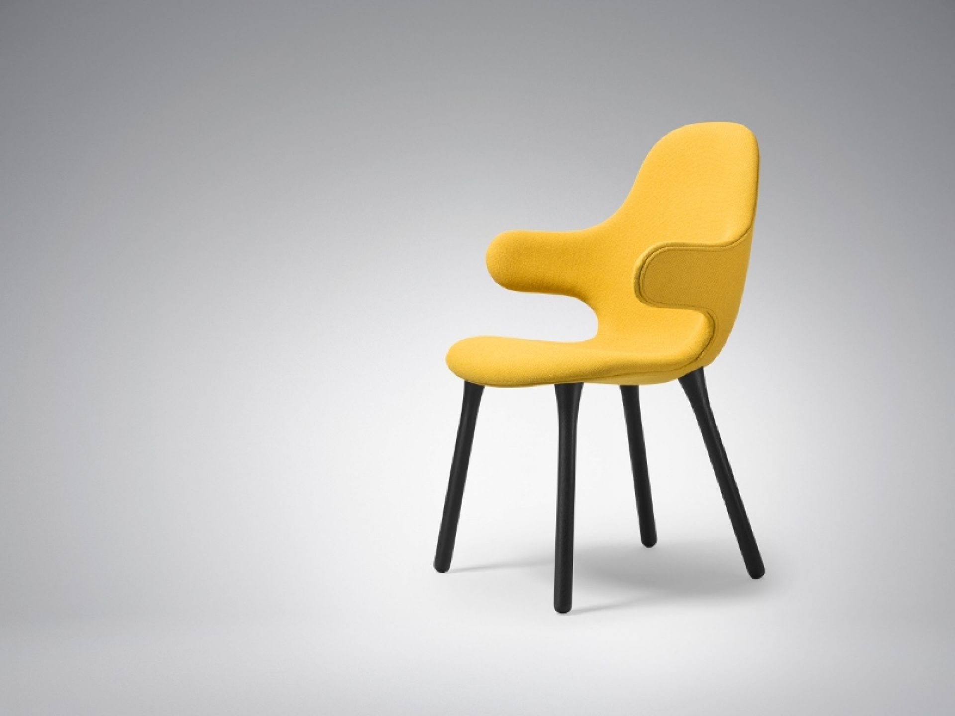 Gelber Catch Chair Stuhl von AndTradition mit schwarzen Holzbeinen, moderner Designstuhl für Wohnzimmer.