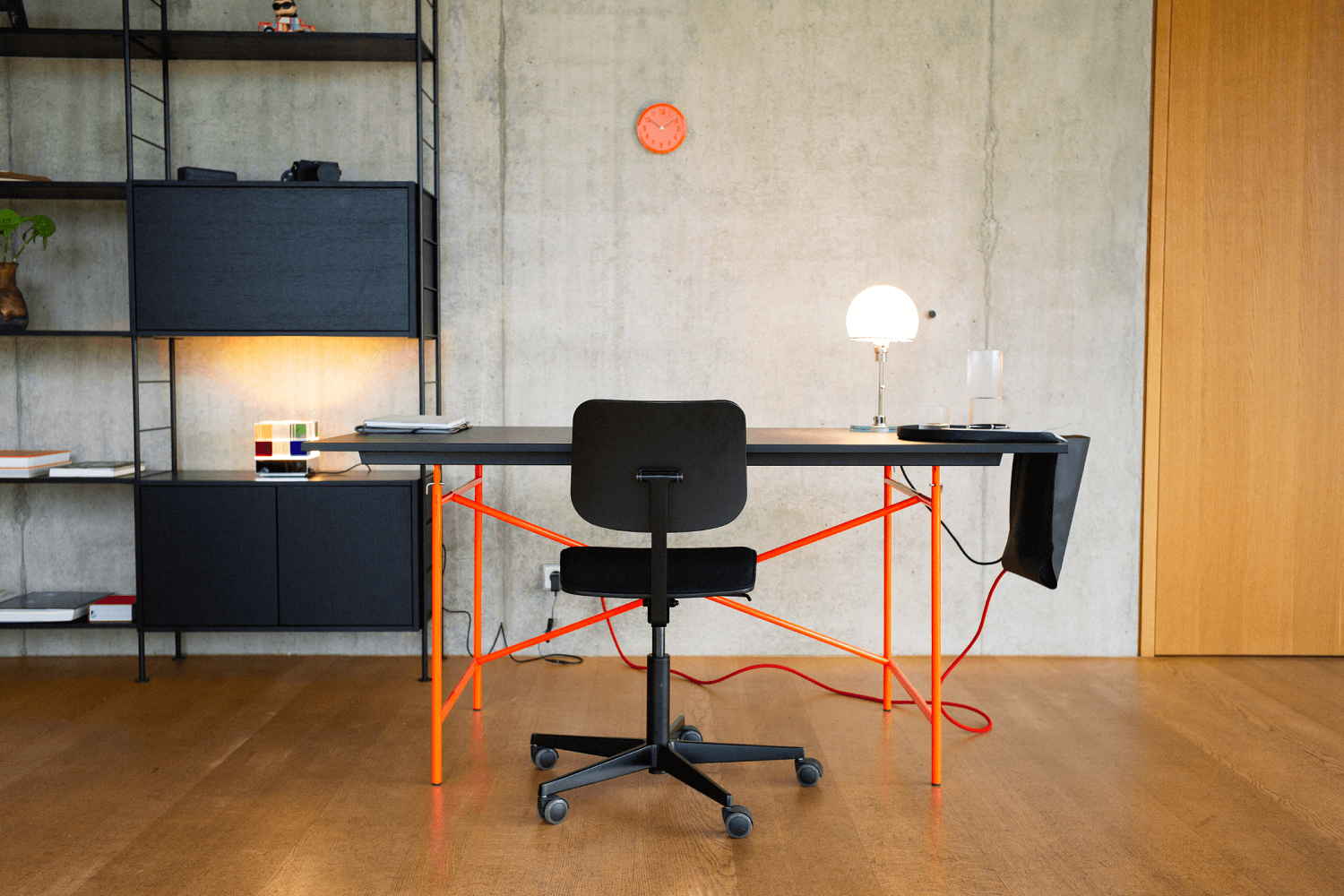 Eiermann Tisch mit orangefarbenem Gestell und schwarzer Tischplatte, ideal als Schreibtisch oder Arbeitstisch.