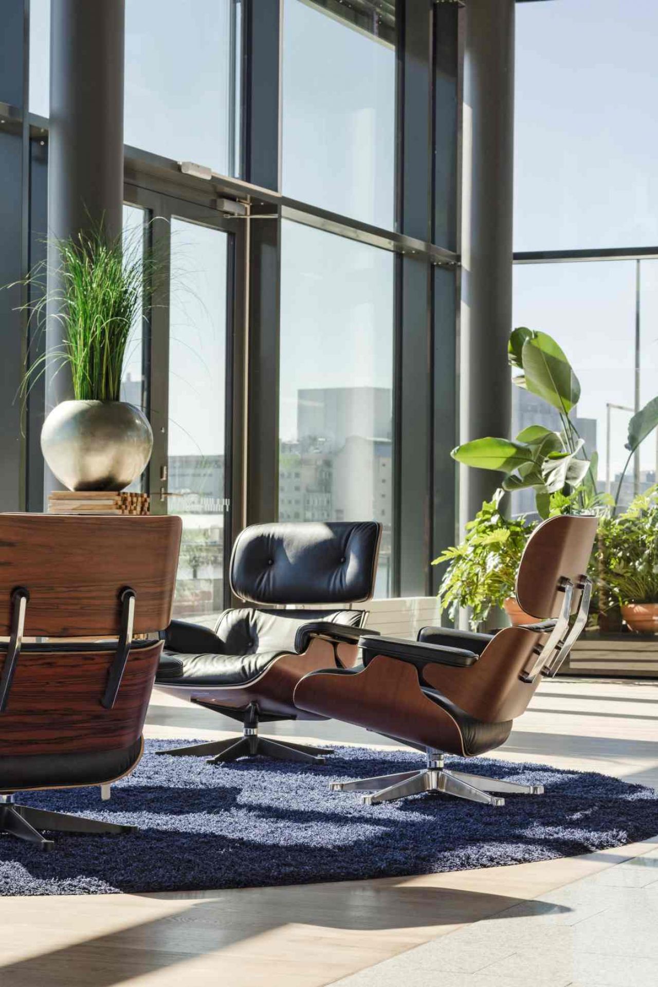Eames Lounge Chair von Vitra mit Ottoman in schwarzem Leder und dunklem Holz.