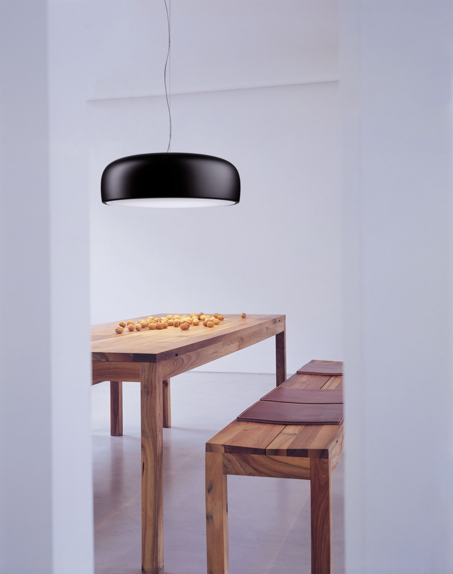Schwarze Smithfield Pendelleuchte von Flos über Esstisch mit Nüssen, moderne Innenraumbeleuchtung.