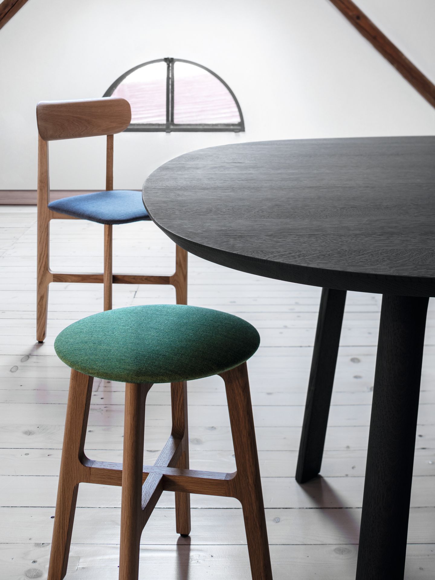 Detailaufnahme: 1.3 Chair Holzstuhl mit amerikanischem Nussbaum, blauer Sitzfläche und grünem Hocker.