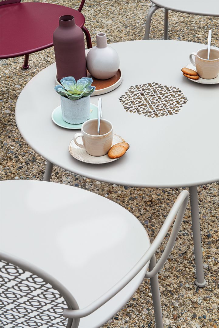 Lorette Beistelltisch von Fermob, runder Outdoor Couchtisch mit Getränken und Dekoration.