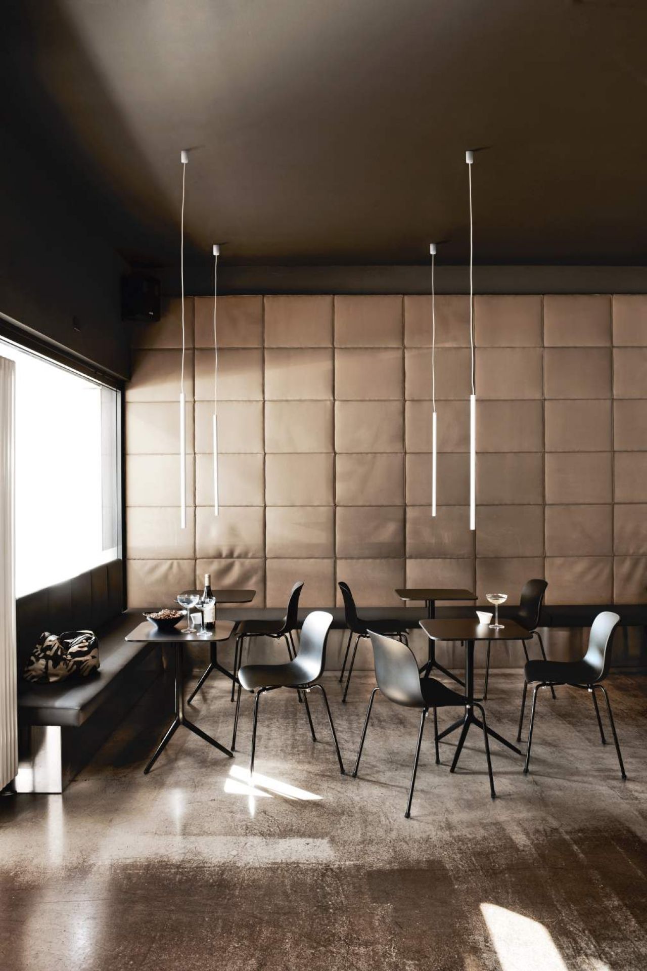 Schwarzer Troy Chair Stuhl mit vier Beinen von Magis in modernem Restaurant-Ambiente.
