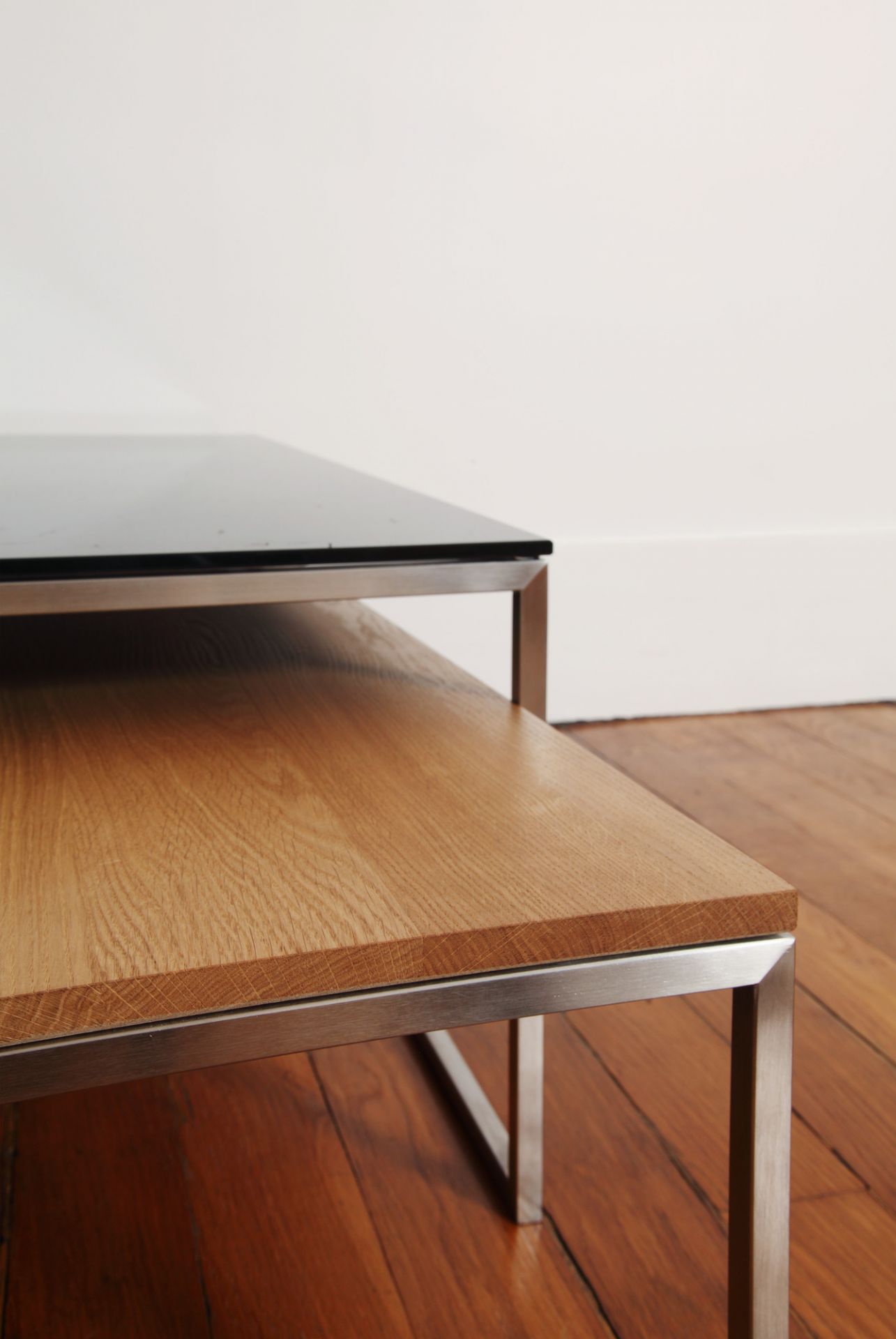 Detailaufnahme: Less H Couchtisch von Hans Hansen mit schwarzer Glasplatte und Holzablage.