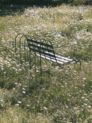 Gardener's Sofa von Design House Stockholm im Garten, umgeben von Gänseblümchen. Outdoor Sofa aus Metall.