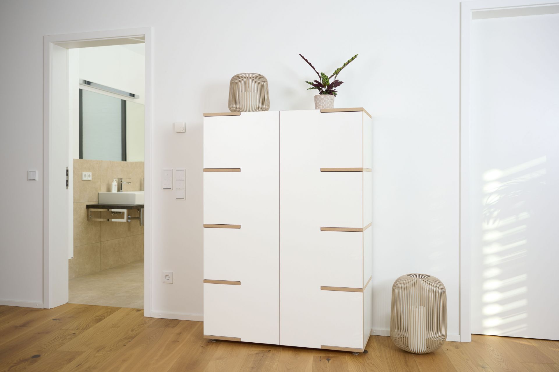 Weißes Tojo Stau Sideboard mit Holzakzenten im modernen Wohnraum, ideal für Stauraum und Ordnung.