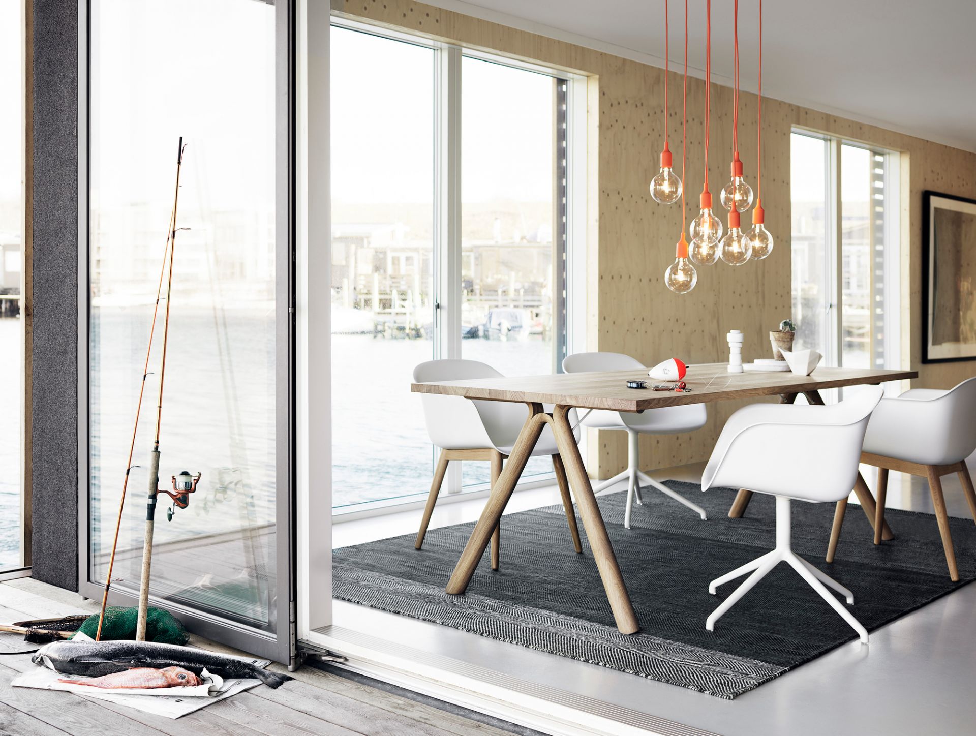 Esszimmer mit Fiber Armchair Stühlen von Muuto, Holztisch und Blick aufs Wasser.