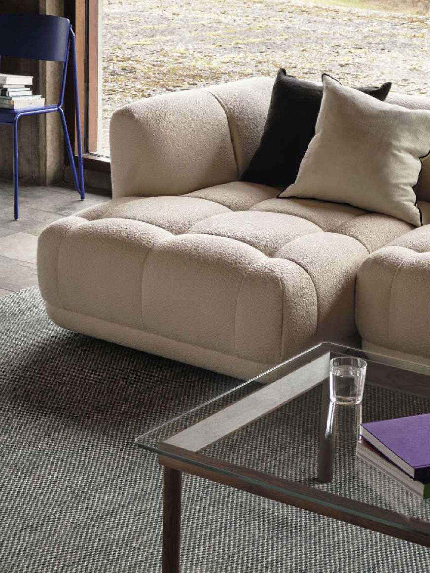 Nahaufnahme des Kofi Couchtisches von Hay mit Walnussgestell und Klarglasplatte im Wohnzimmer.