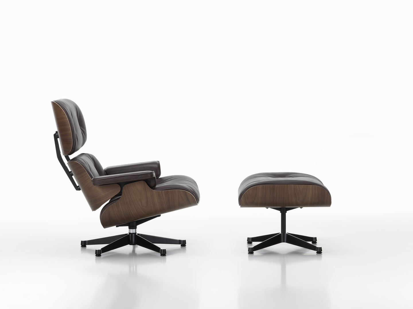 Eames Lounge Chair mit Ottoman in braunem Leder und dunklem Holz auf weißem Hintergrund.