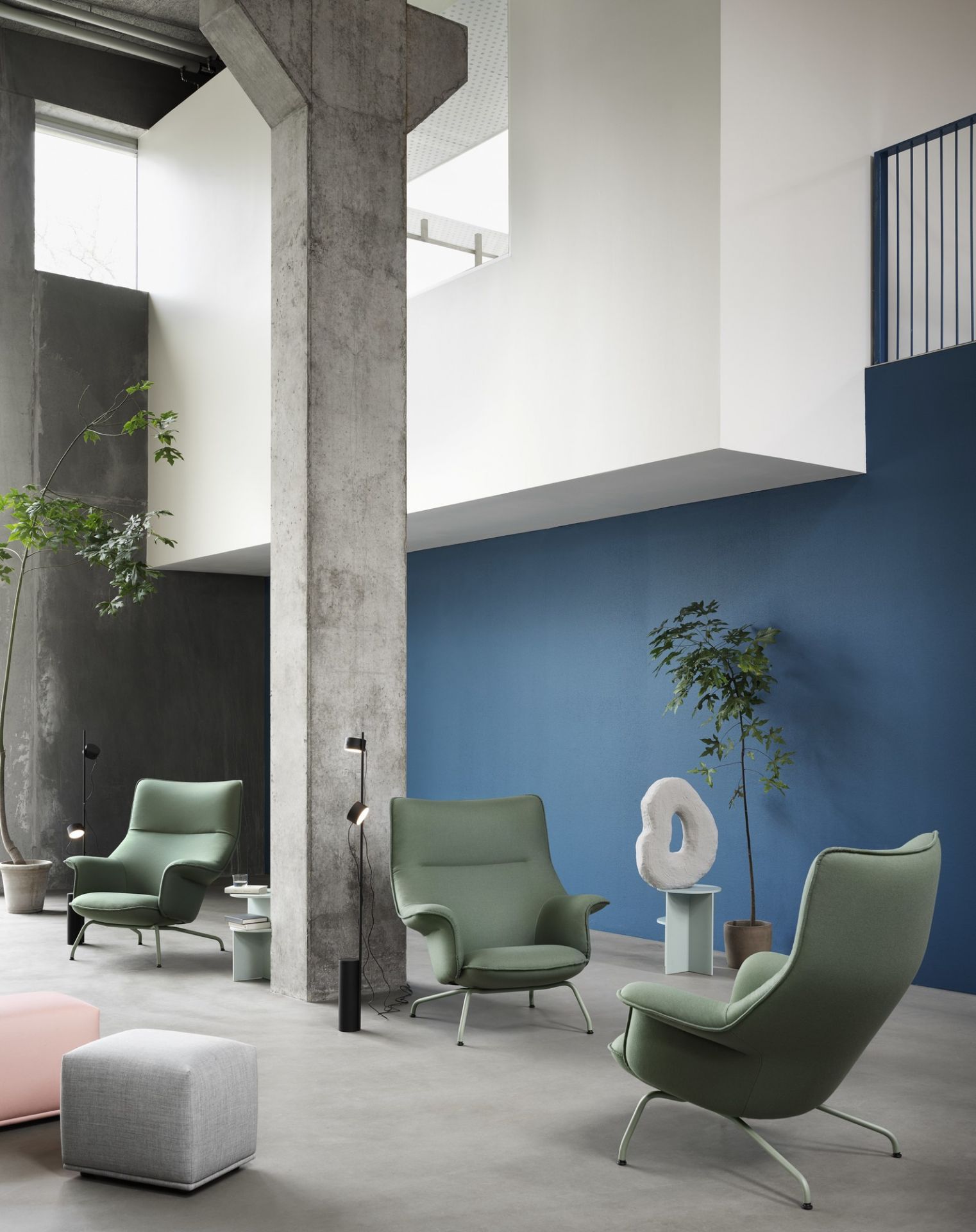 Minimalistische Einrichtung mit Muuto Post Floor Lamp Stehleuchte und grünen Sesseln.