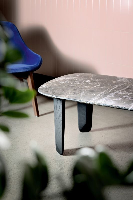Detailaufnahme des Kuyu Marble Couchtisches mit rechteckiger Marmorplatte und dunklen Holzbeinen, stilvolles Wohnzimmerdesign.