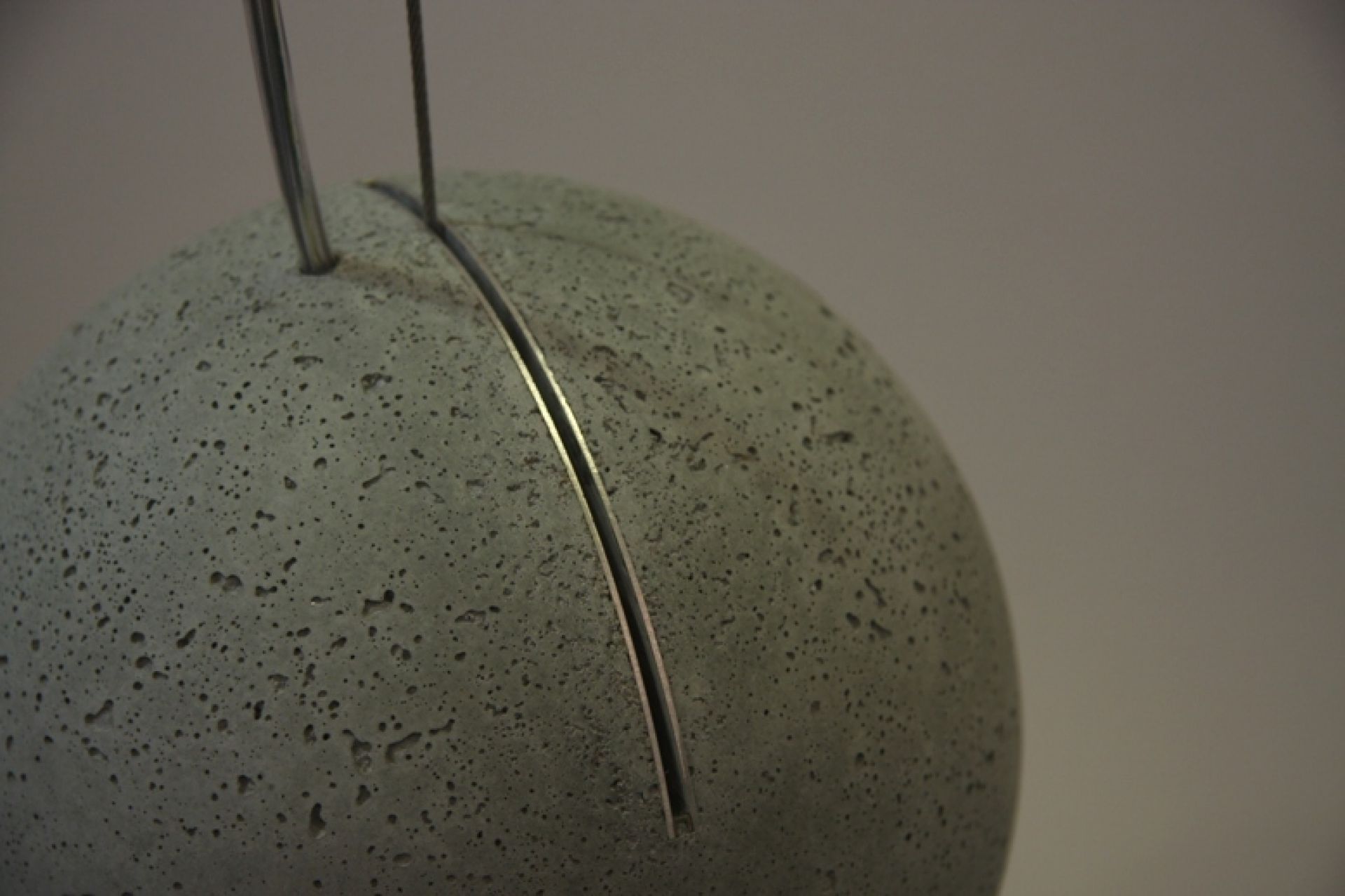 Nahaufnahme einer modernen Beton-Pendelleuchte mit Metalleinsatz, ideal für minimalistische Inneneinrichtung und stilvolle Beleuchtung.