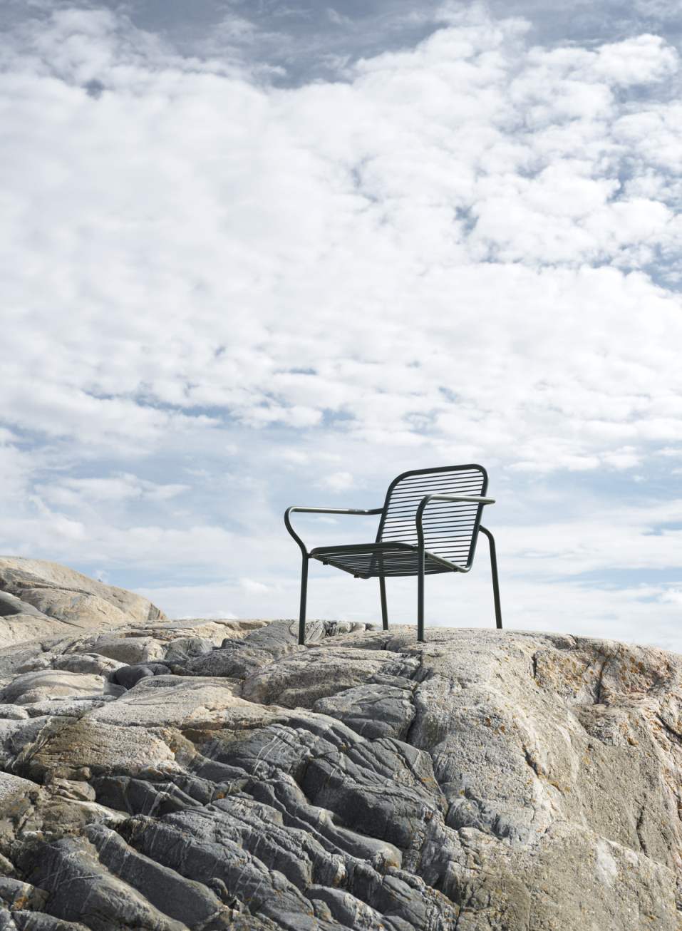 Normann Copenhagen Vig Lounge Chair Outdoor Sessel auf Felsen mit Blick auf den Himmel.