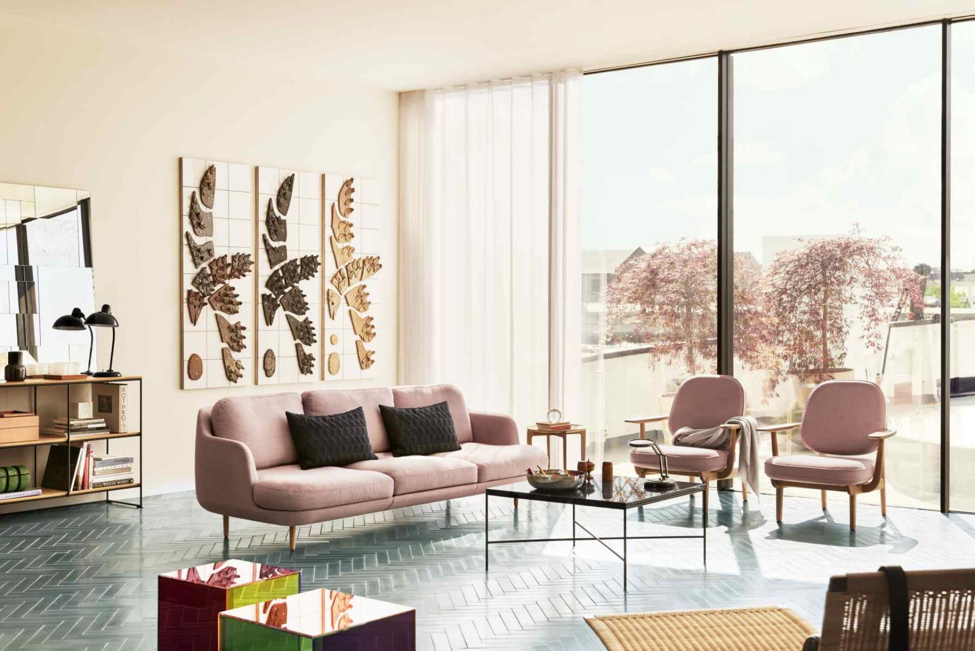 Rosa Fred Loungesessel von Fritz Hansen in modernem Wohnzimmer mit Sofa, Tisch und Kunst.