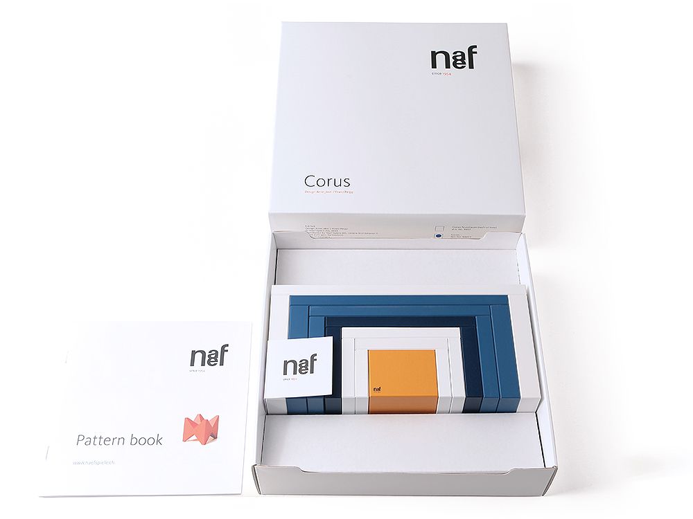 Naef Corus Steckspiel in geöffneter Verpackung mit Musterbuch, hochwertiges Holzspielzeug für Kinder und Erwachsene.