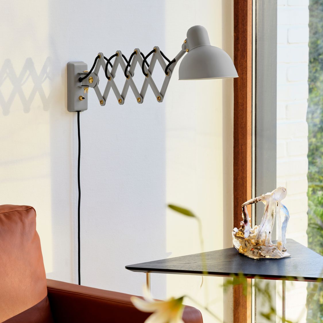 Graue KAISER idell Scherenleuchte 6718 von Fritz Hansen an der Wand montiert. Design Lampe.