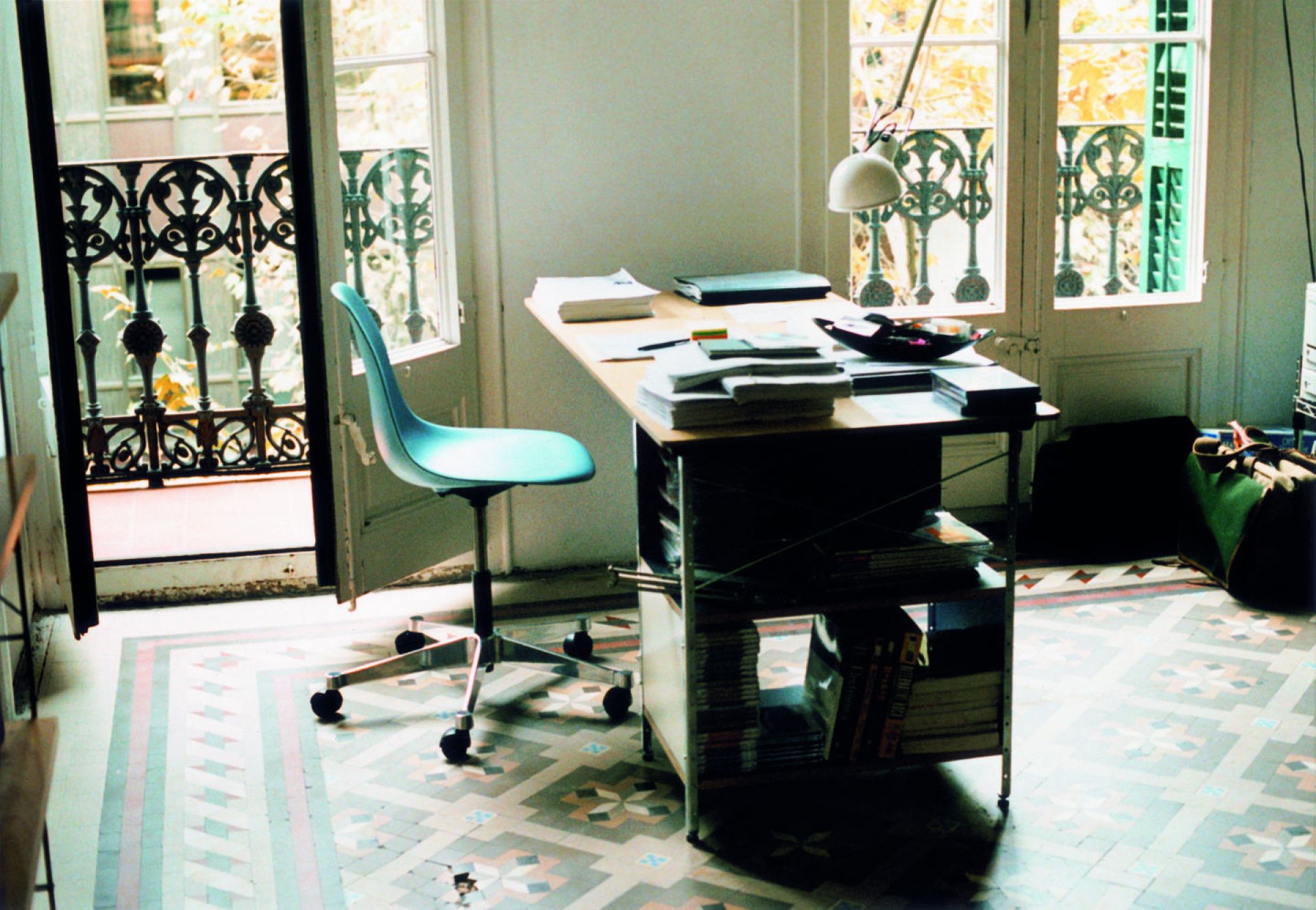 Büro mit blauem Eames Plastic Side Chair Drehstuhl von Vitra am Schreibtisch.