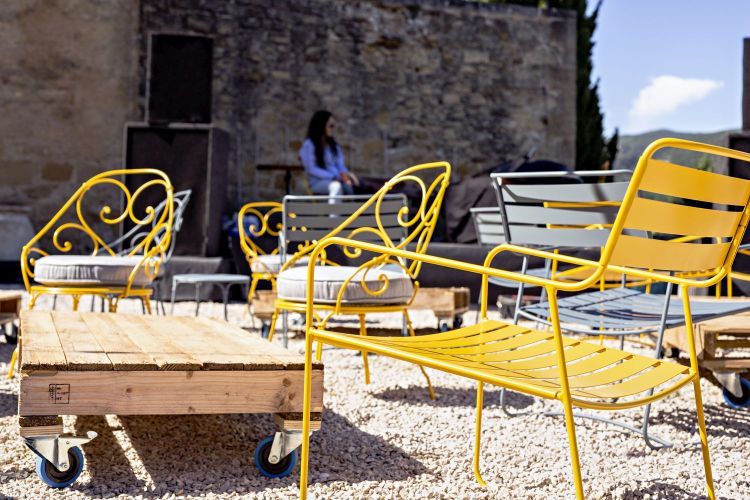 Gelbe Fermob Surprising Outdoor Sessel und Holztisch auf Rollen im Garten, moderne Gartenmöbel.