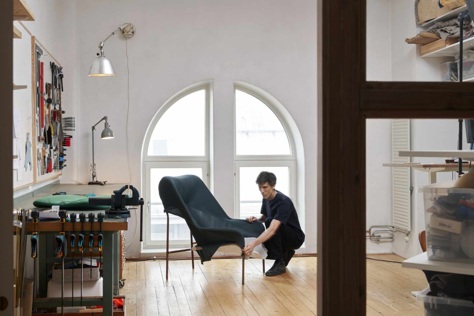 Mann montiert einen 02 Lounge Chair Sessel von Hay in einer Werkstatt mit Werkzeugen.