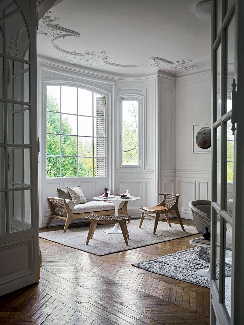 Heller Raum mit Klismos Lounge Sessel von Knoll International, ergänzt durch Beistelltisch und Hocker.