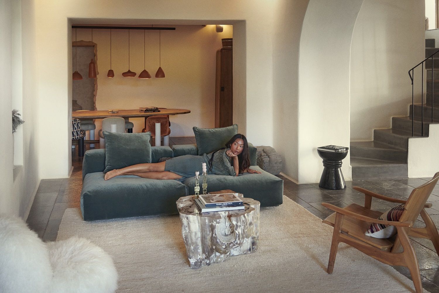 Frau entspannt auf modernem, türkisfarbenen vetsak Sofa Set 04. Gemütliches Wohnzimmer mit Designermöbeln und stilvoller Dekoration.