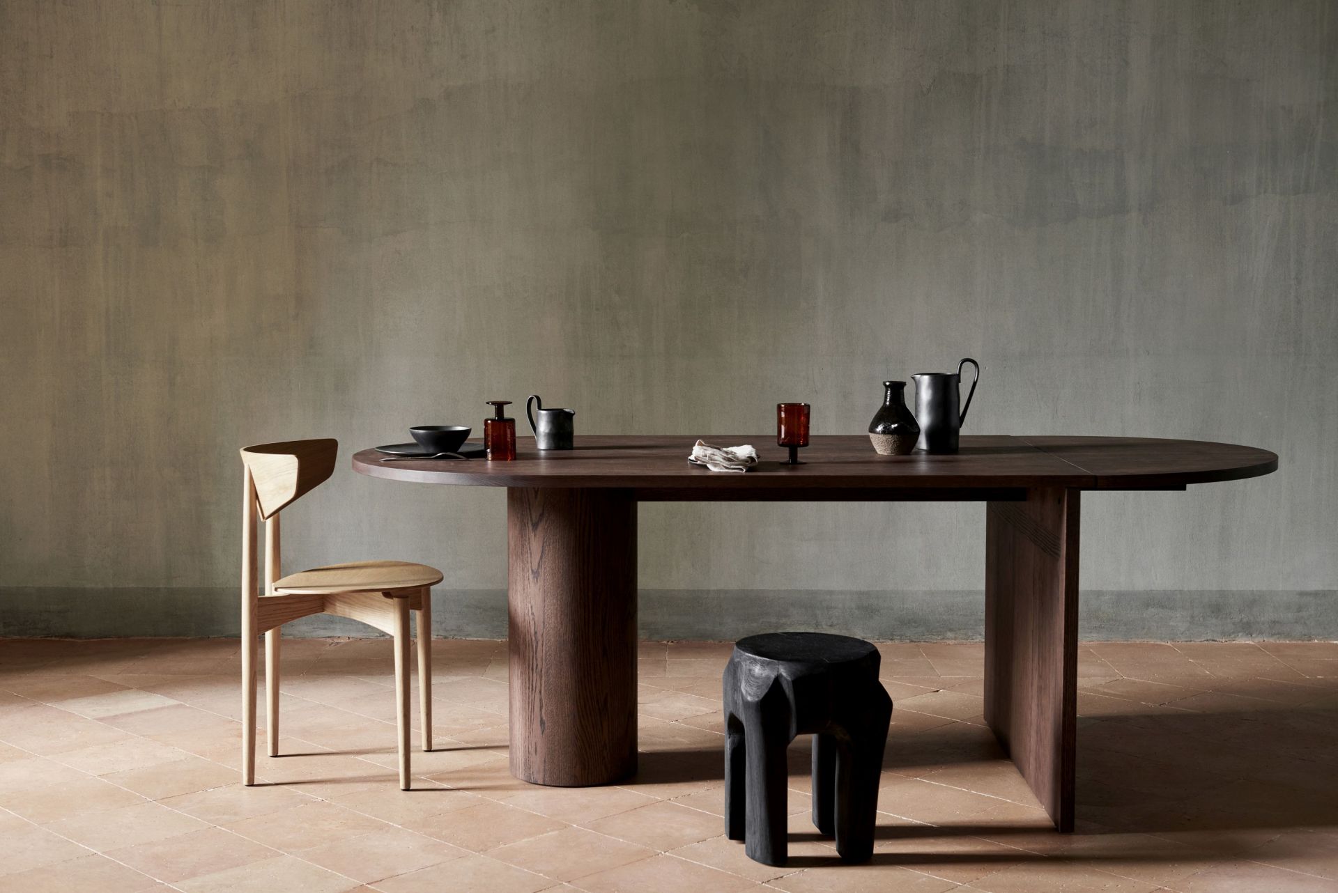 Pylo Esstisch von Ferm Living aus dunkel gebeizter Eiche mit Stuhl und Dekoration.