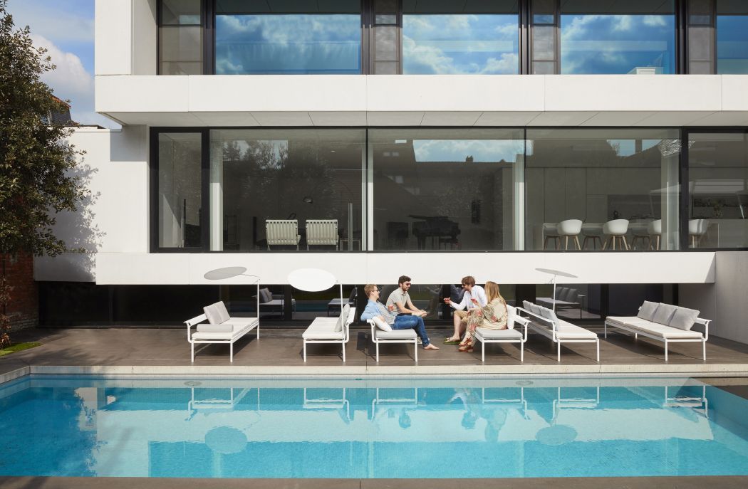 Sol + Luna Sonnenliege von Extremis am Pool, vier Personen sitzen und entspannen im Freien.