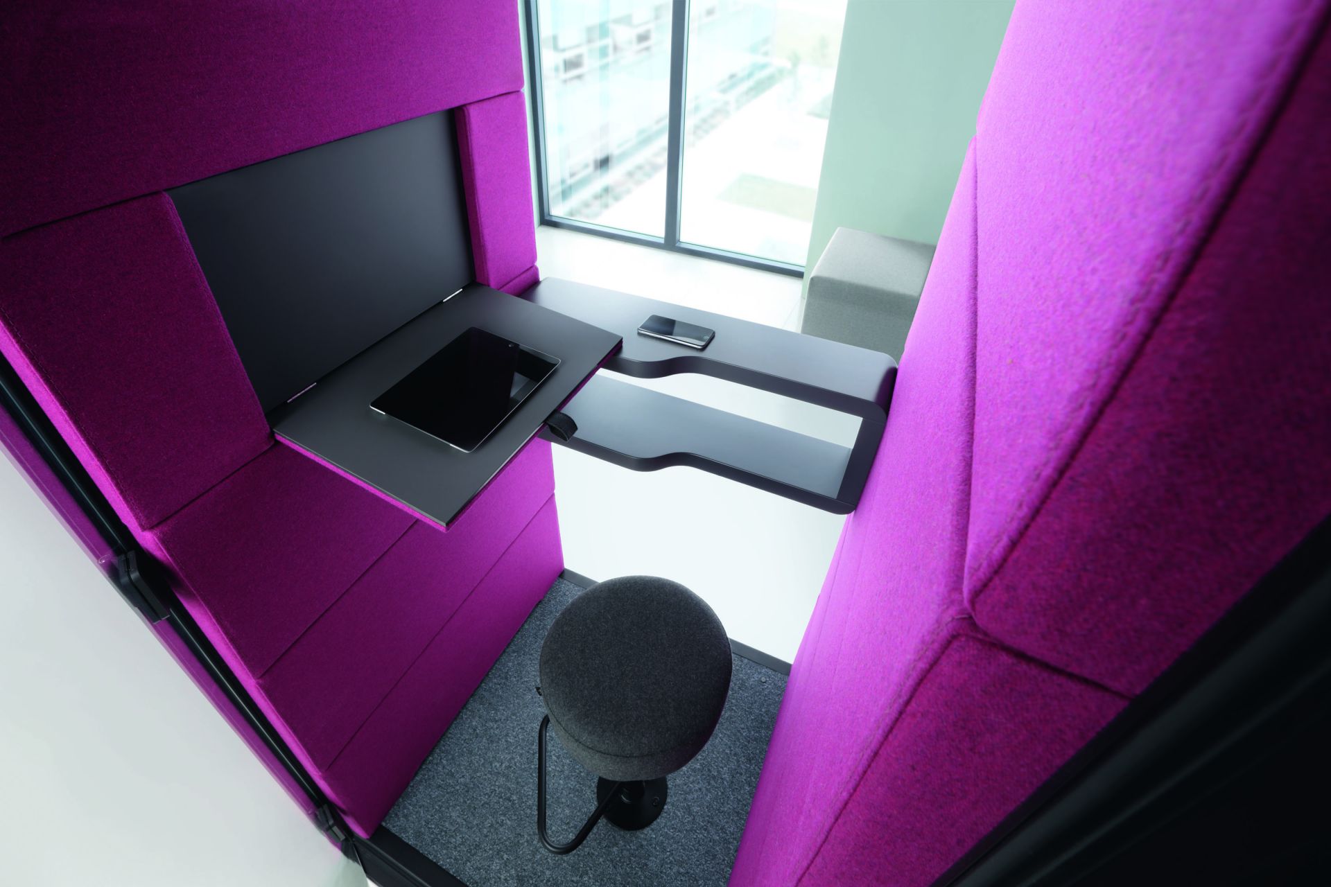 HushPhone Meetingbox: Innenansicht der Telefonzelle mit Tisch, Tablet, Handy und Hocker. Büro Akustiklösung.