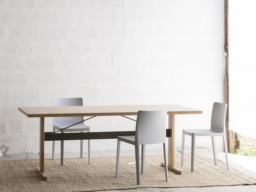 Heller Hay Esstisch Passerelle Table aus Holz mit drei grauen Stühlen auf einem Teppich.