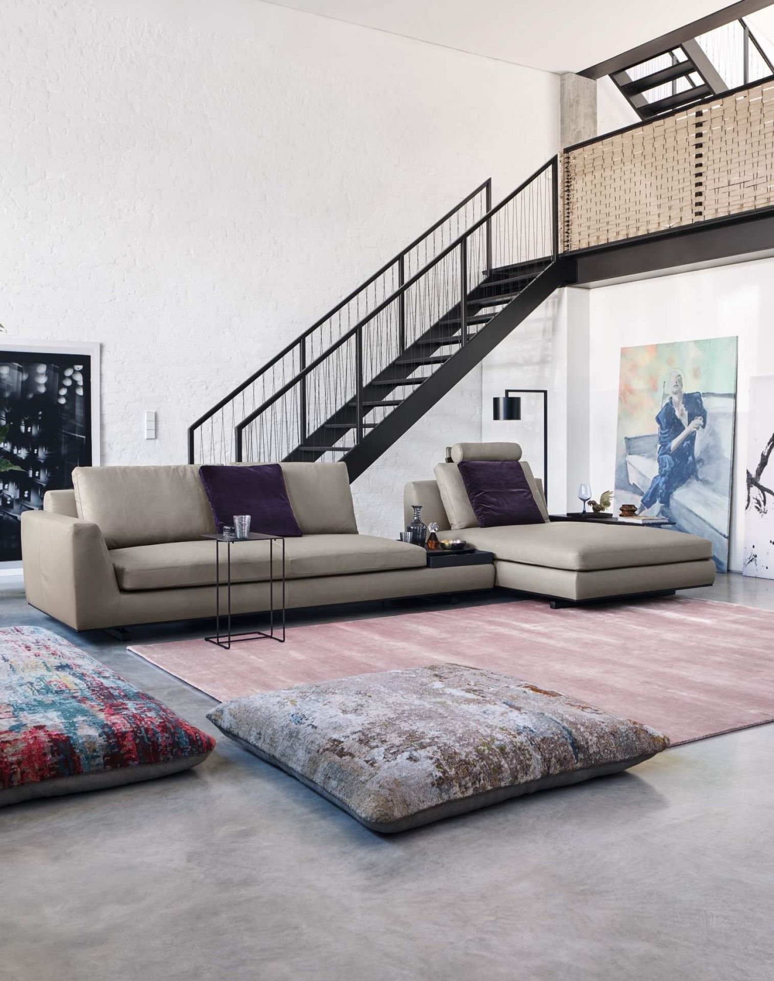 Oki Beistelltisch von Walter Knoll neben beigem Sofa in modernem Wohnzimmer mit Treppe.